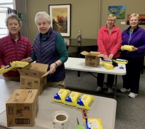 Volunteer Dominican Sisters Doris Faber, Joellen Barkwell, Jarrett DeWyse, and Carman Rostar labeling supplies at The StoreHouse.