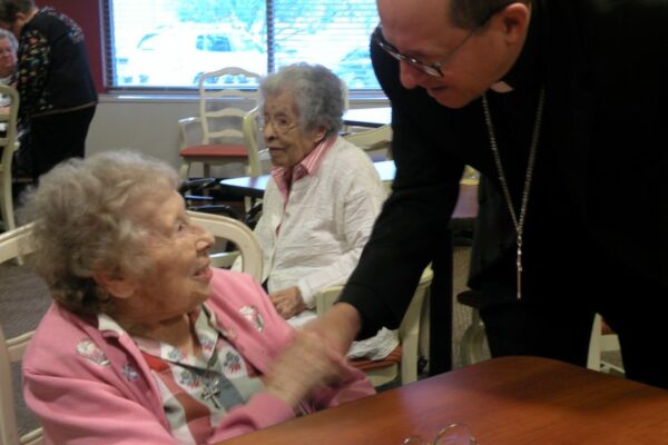 Sister Marie Bernarde greets Grand Rapids Diocese Bishop Walkowiak during a visit at Aquinata Hall.
