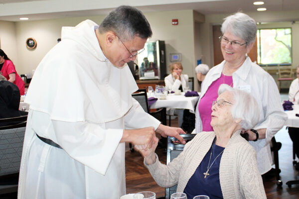 Sr. Teresa Houlhan greets Master of the Dominican Order Fr. Gerard Timoner, III, OP, July 7, 2026, with Prioress Sr. Megan McElroy, OP.